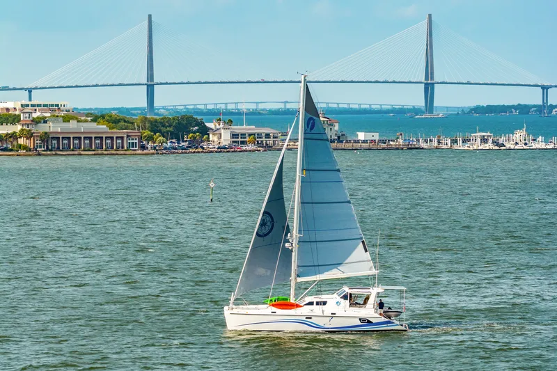 Slide: The Image of Sailboat St Francis SF 50, 2010 model, cruising near a bridge and marina. - 12