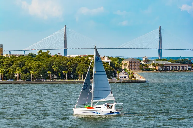 Slide: The Image of Sailboat St Francis SF 50, 2010 model, cruising near a scenic bridge and waterfront. - 13