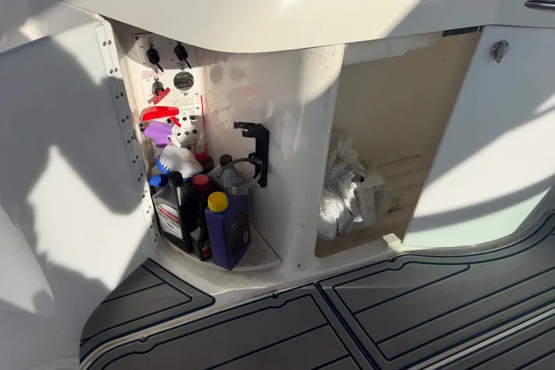 Slide: The Image of Storage compartment on a 2003 Formula 330 Sun Sport boat with cleaning supplies and tools. - 14