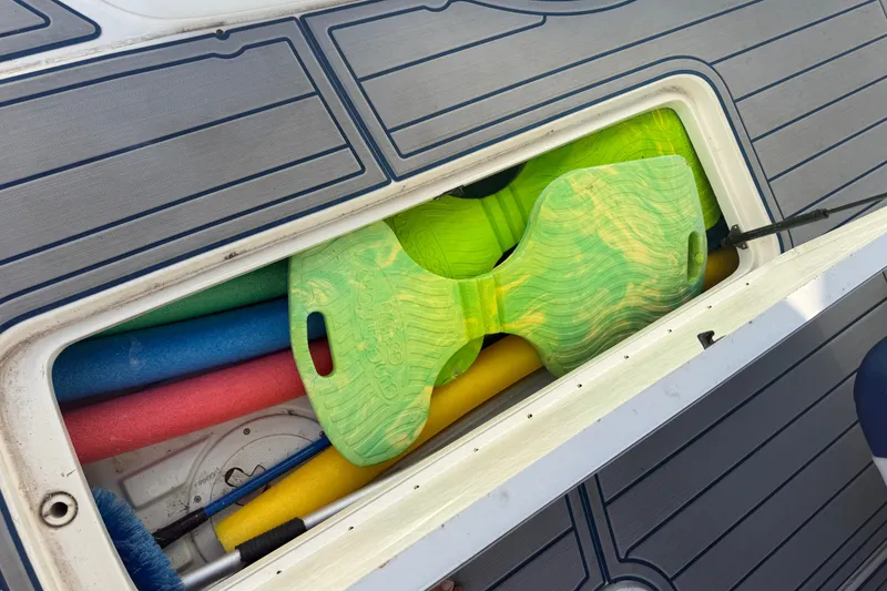 Slide: The Image of Storage compartment on 2003 Formula 330 Sun Sport with colorful pool noodles and green float. - 19