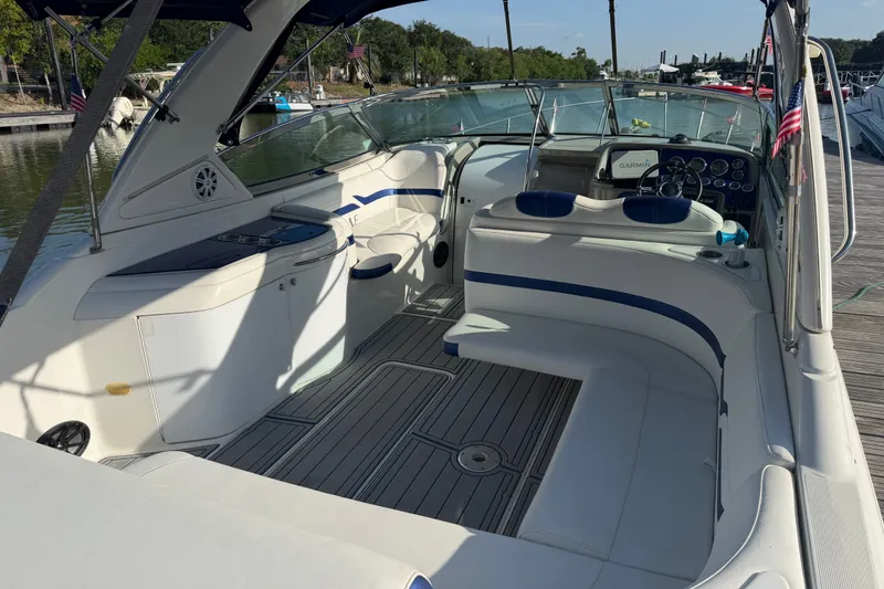 Slide: The Image of 2003 Formula 330 Sun Sport boat interior with seating and dashboard at a marina. - 10