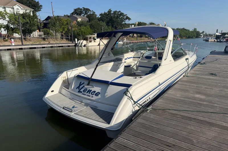 Slide: The Image of 2003 Formula 330 Sun Sport boat docked on a sunny day, featuring sleek design and blue accents. - 6