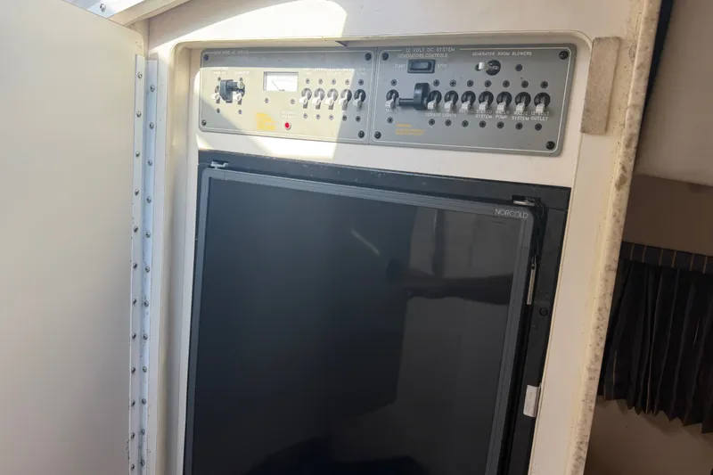 Slide: The Image of Control panel and refrigerator inside a 2003 Formula 330 Sun Sport boat. - 36