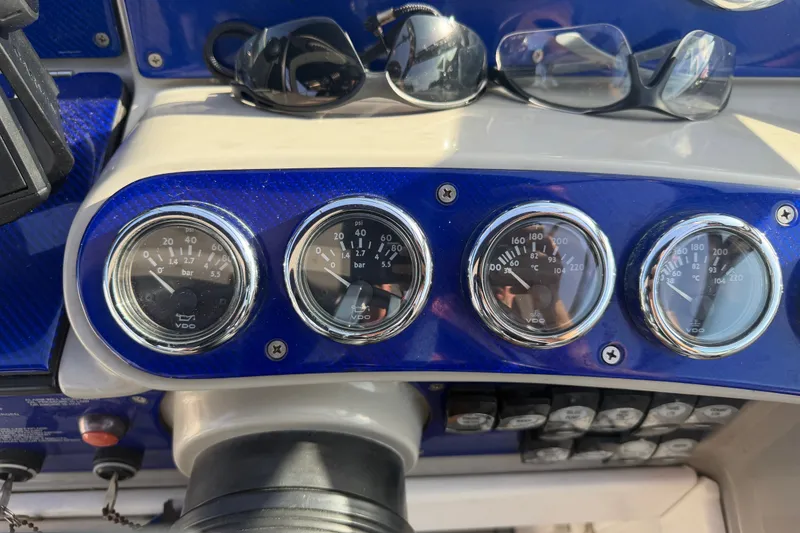 Slide: The Image of Dashboard of a 2003 Formula 330 Sun Sport boat with gauges and sunglasses. - 21