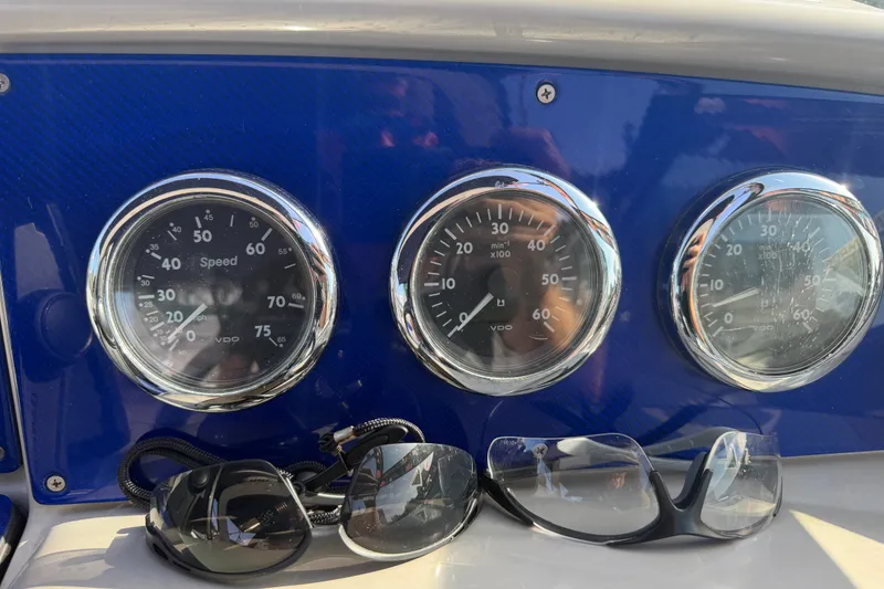 Slide: The Image of Dashboard of a 2003 Formula 330 Sun Sport boat with gauges and sunglasses. - 22