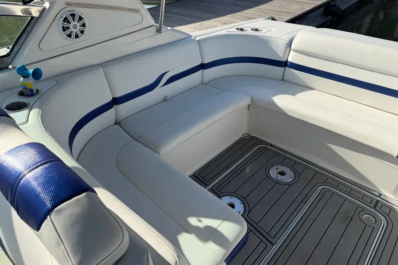 Slide: The Image of 2003 Formula 330 Sun Sport boat interior with white and blue seating, docked by the water. - 16