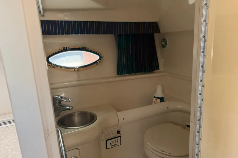 Slide: The Image of 2003 Formula 330 Sun Sport boat bathroom with sink, toilet, and porthole window. - 35