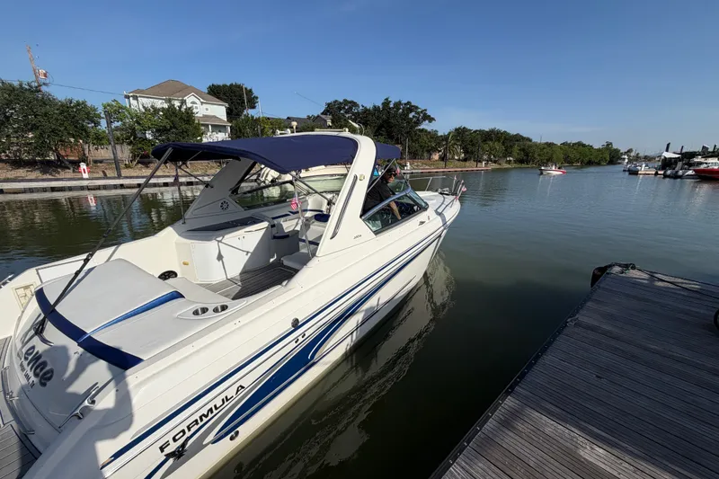 Slide: The Image of 2003 Formula 330 Sun Sport boat docked on a sunny day, featuring sleek design and canopy. - 5
