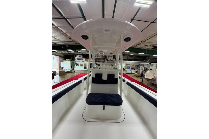Slide: The Image of 2027 Parker 240 Coastal Elite boat interior with seating, showcased in a spacious indoor setting. - 18