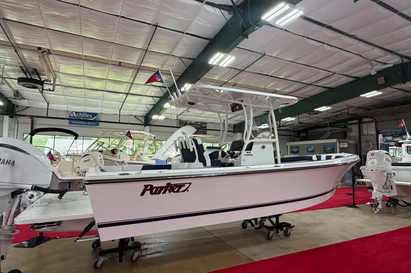 The Image of 2027 Parker 240 Coastal Elite boat displayed in a showroom with red carpet flooring. - 1