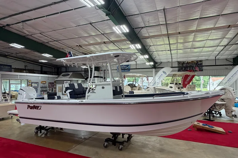 Slide: The Image of 2027 Parker 240 Coastal Elite boat displayed in a showroom with red carpet. - 4