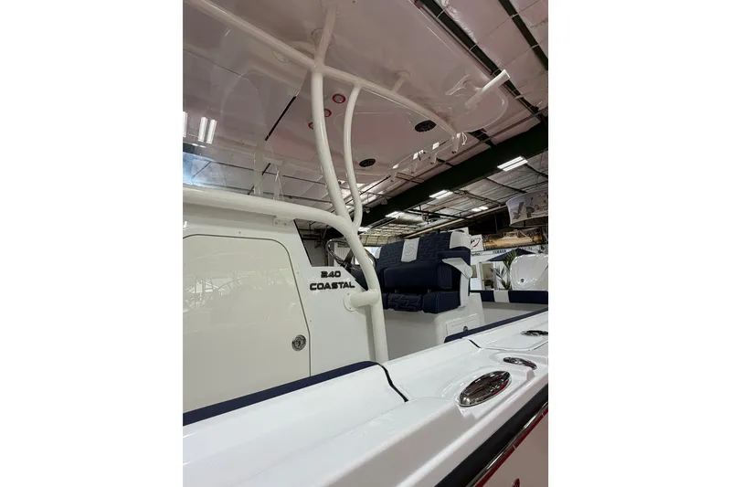 Slide: The Image of 2027 Parker 240 Coastal Elite boat interior with seating and storage, showcased in a well-lit showroom. - 6