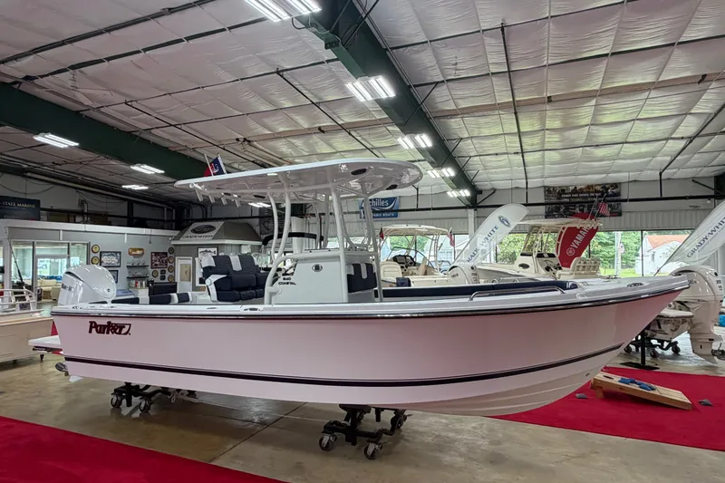 Slide: The Image of 2027 Parker 240 Coastal Elite boat displayed in a showroom with red carpet flooring. - 5