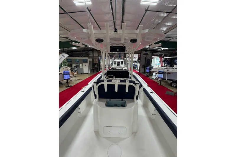 Slide: The Image of 2027 Parker 240 Coastal Elite boat interior at a showroom with red carpet. - 9