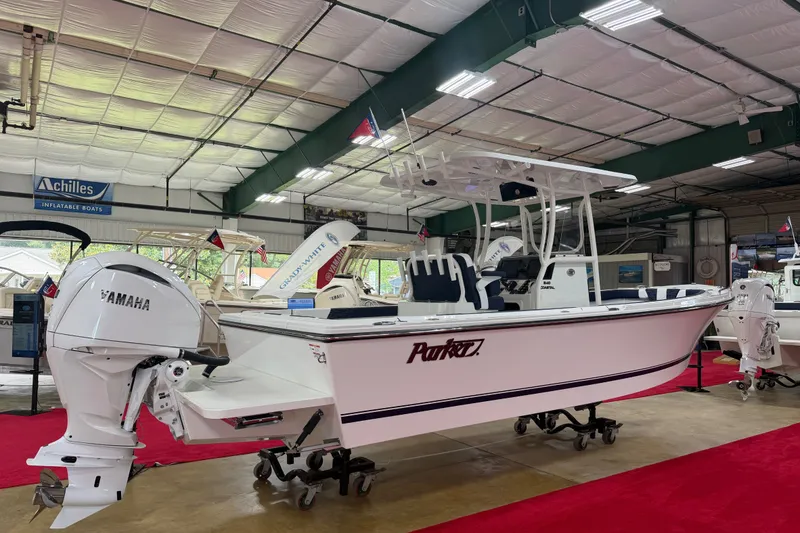Slide: The Image of 2027 Parker 240 Coastal Elite boat displayed indoors with Yamaha engine on red carpet. - 2