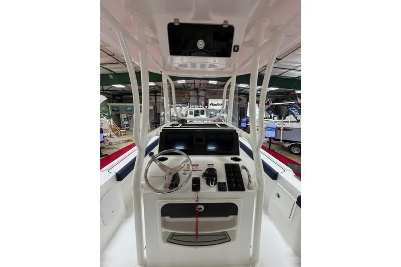 Slide: The Image of Interior view of 2027 Parker 240 Coastal Elite boat cockpit with steering wheel and controls. - 14