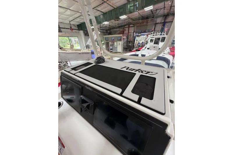 Slide: The Image of 2027 Parker 240 Coastal Elite boat interior in showroom, showcasing dashboard and controls. - 15