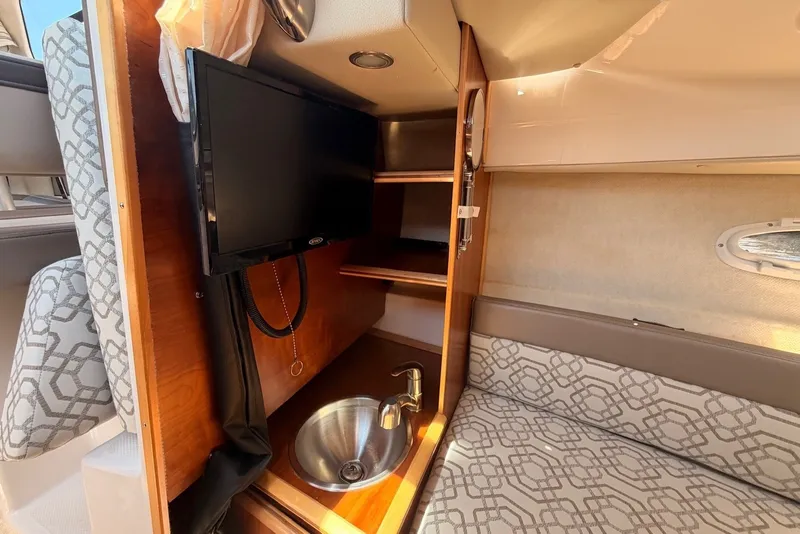 Slide: The Image of 2022 Cutwater C-24 Coupe interior with TV, sink, and patterned seating. - 10