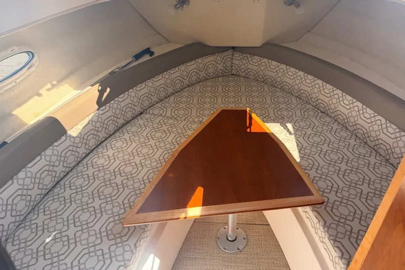 Slide: The Image of Interior of 2022 Cutwater C-24 Coupe with patterned seating and wooden table. - 9