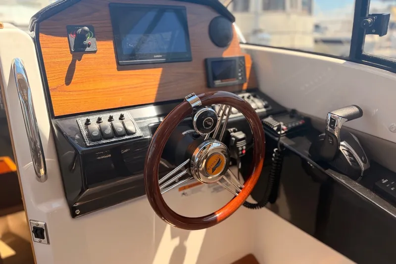Slide: The Image of Interior helm of 2022 Cutwater C-24 Coupe with wooden steering wheel and control panel. - 7