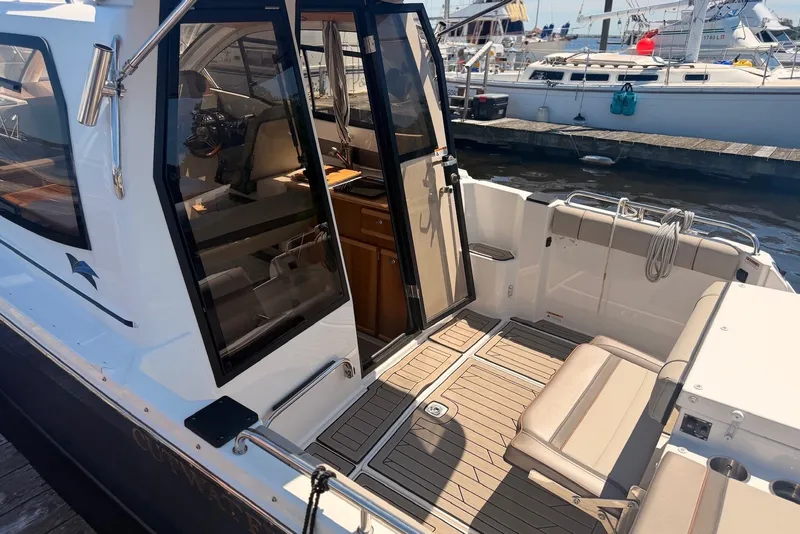Slide: The Image of 2022 Cutwater C-24 Coupe boat interior with seating and dock view. - 3