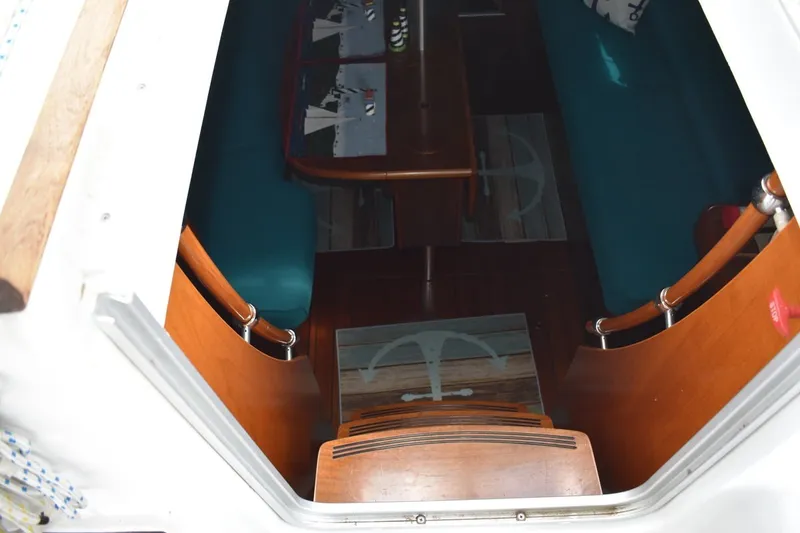 Slide: The Image of Interior view of 1999 Beneteau Oceanis 36 CC sailboat, featuring wooden steps and teal seating. - 21