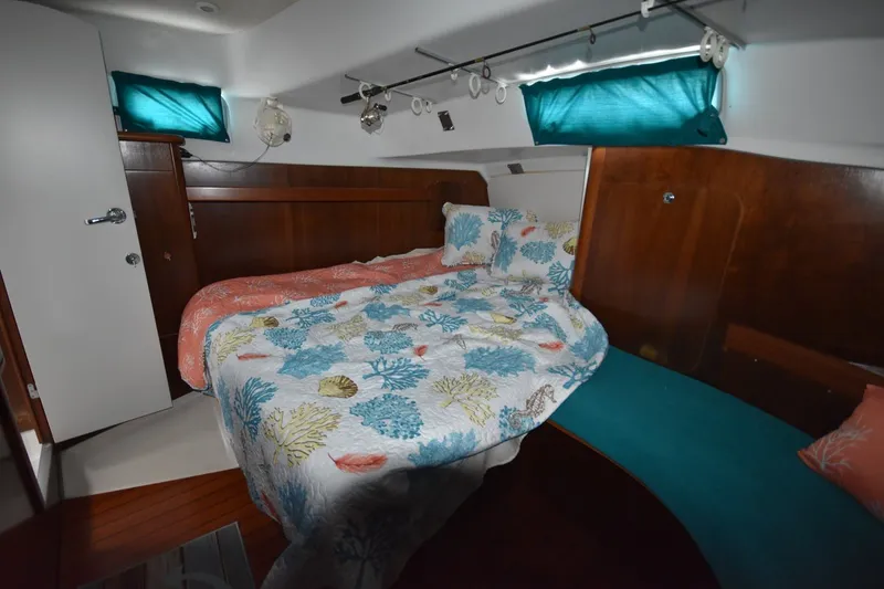 Slide: The Image of Cozy cabin interior of 1999 Beneteau Oceanis 36 CC with colorful bedding and wood accents. - 38