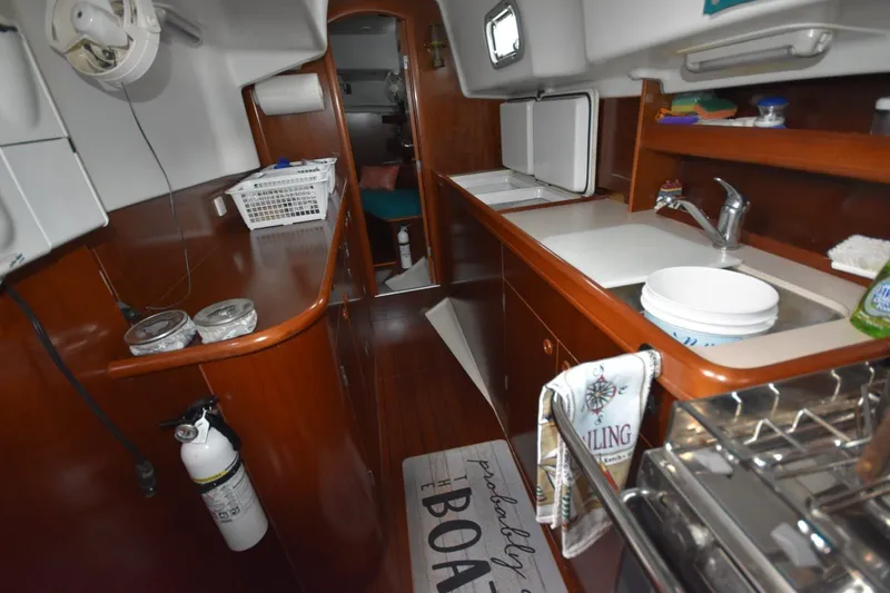 Slide: The Image of Interior of 1999 Beneteau Oceanis 36 CC sailboat, featuring a compact kitchen area. - 33