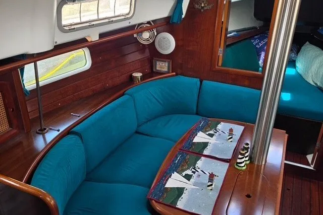 Slide: The Image of Interior of 1999 Beneteau Oceanis 36 CC sailboat with teal seating and wooden finishes. - 25