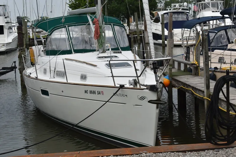 Slide: The Image of 1999 Beneteau Oceanis 36 CC sailboat docked at marina, featuring green canopy. - 1