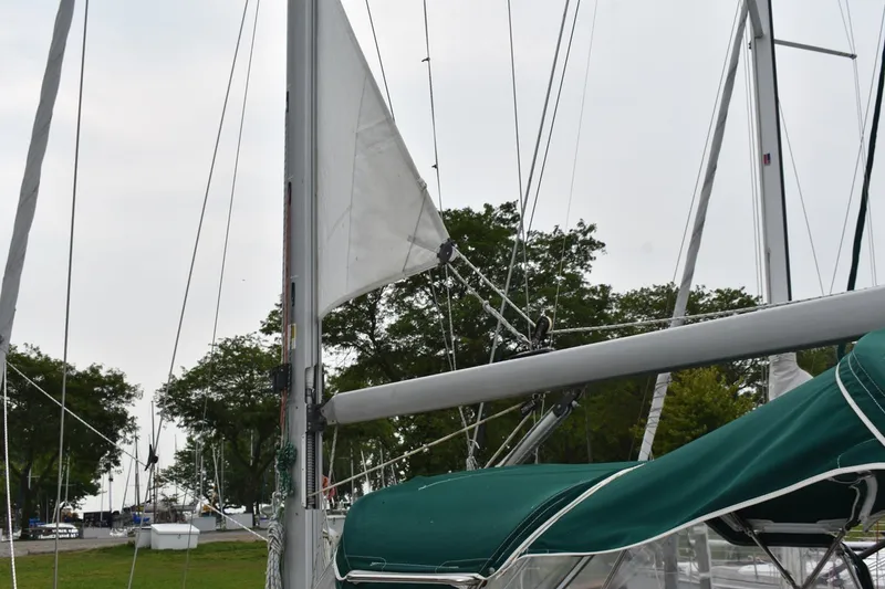 Slide: The Image of Sailboat mast and rigging of a 1999 Beneteau Oceanis 36 CC, docked with green sail cover. - 16