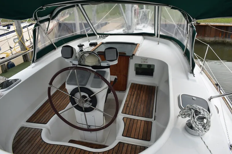 Slide: The Image of Cockpit of 1999 Beneteau Oceanis 36 CC sailboat with wooden flooring and steering wheel. - 13