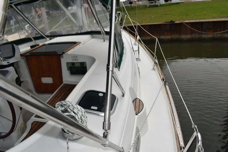 Slide: The Image of 1999 Beneteau Oceanis 36 CC sailboat deck view, featuring sleek design and mooring ropes. - 14