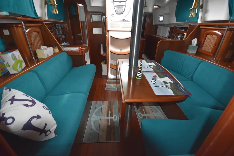 Slide: The Image of Interior of 1999 Beneteau Oceanis 36 CC sailboat with teal seating and wooden accents. - 30