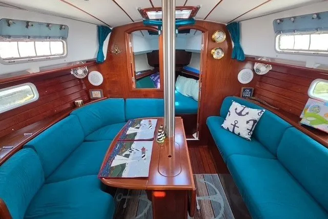 Slide: The Image of Interior of 1999 Beneteau Oceanis 36 CC sailboat with teal seating and wooden accents. - 22