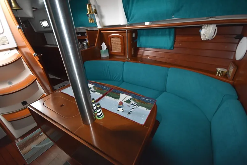 Slide: The Image of Interior of 1999 Beneteau Oceanis 36 CC sailboat with teal seating and wooden accents. - 29