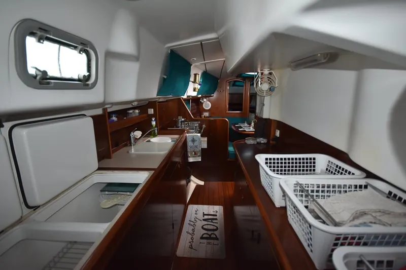 Slide: The Image of Interior of 1999 Beneteau Oceanis 36 CC sailboat, featuring a compact galley and dining area. - 34