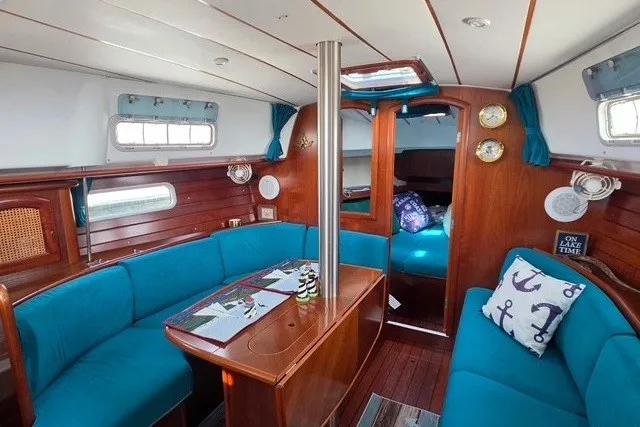 Slide: The Image of Interior of 1999 Beneteau Oceanis 36 CC sailboat with blue seating and wooden finishes. - 27