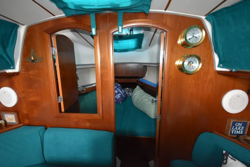 Slide: The Image of Interior of a 1999 Beneteau Oceanis 36 CC sailboat with wooden finish and teal upholstery. - 23