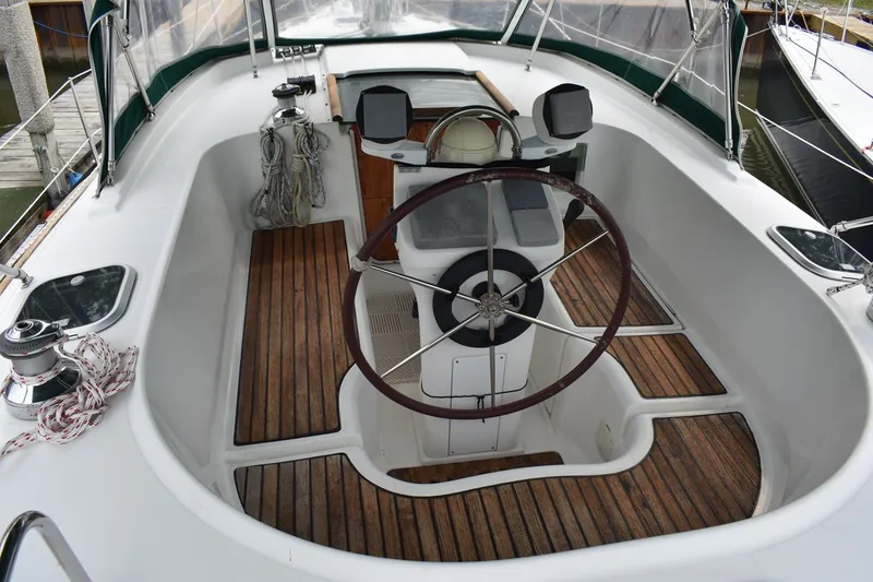 Slide: The Image of Cockpit of 1999 Beneteau Oceanis 36 CC sailboat with wooden flooring and steering wheel. - 11