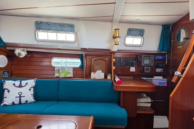 Slide: The Image of Interior of 1999 Beneteau Oceanis 36 CC sailboat with blue seating and wooden accents. - 28