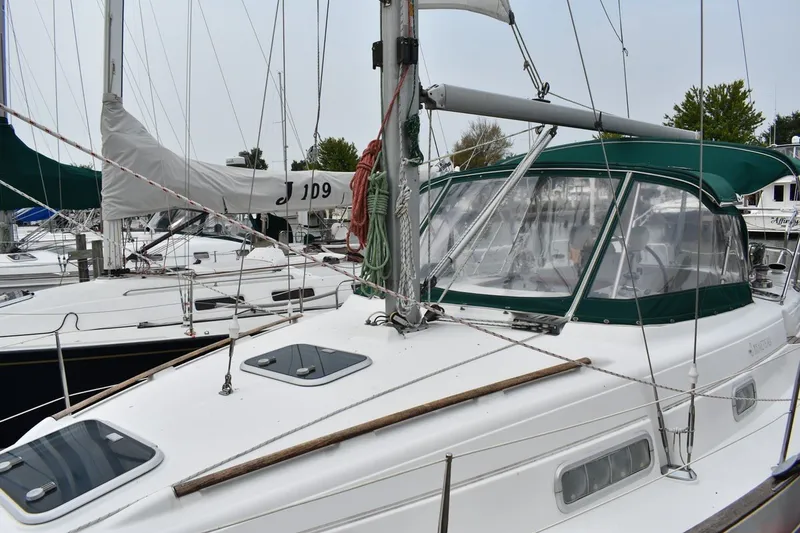 Slide: The Image of 1999 Beneteau Oceanis 36 CC sailboat docked, featuring green canopy and sleek design. - 4