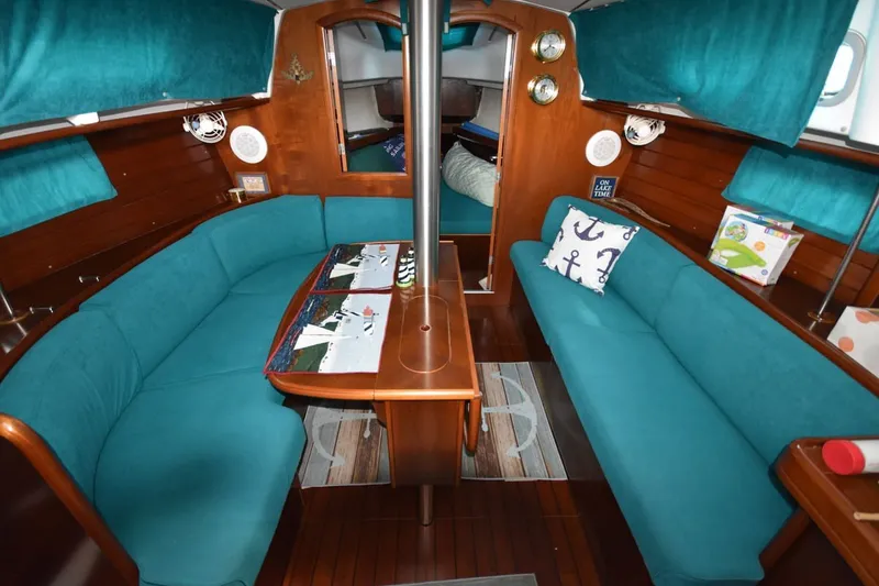 Slide: The Image of Interior of 1999 Beneteau Oceanis 36 CC sailboat with teal seating and wooden accents. - 26