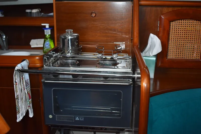 Slide: The Image of Galley kitchen in 1999 Beneteau Oceanis 36 CC sailboat with stove and wooden cabinetry. - 47