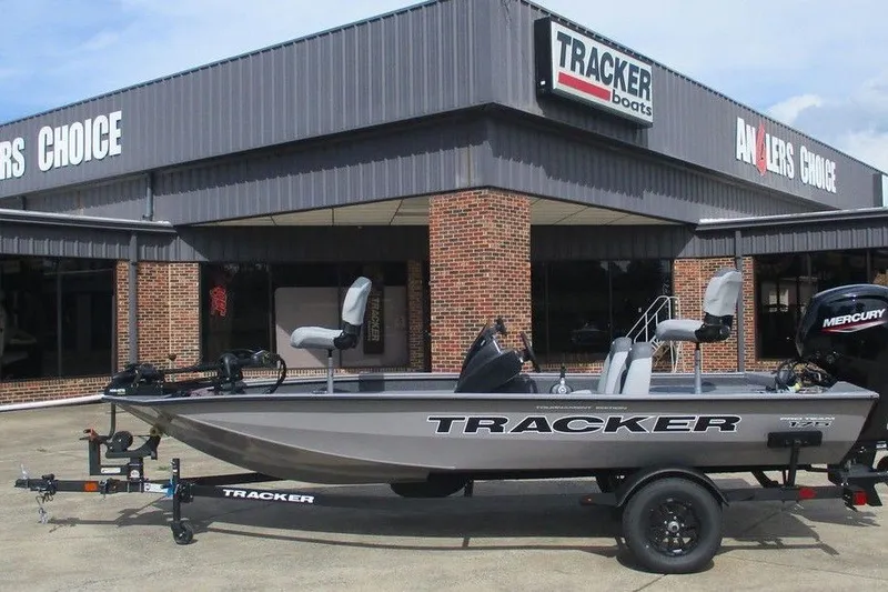 The Image of 2027 Tracker Pro Team 175 boat displayed outside dealership, featuring sleek design and Mercury engine. - 1