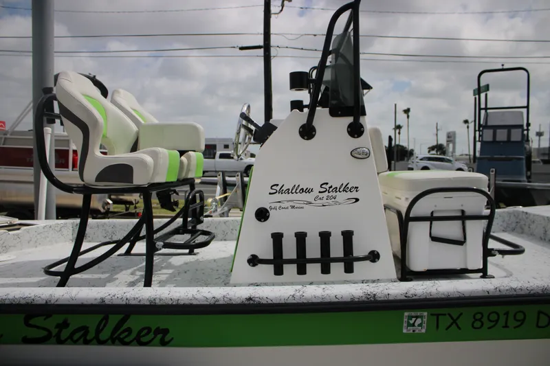 Slide: The Image of 2018 Shallow Stalker 204 RC boat with green and white seating, docked outdoors. - 14