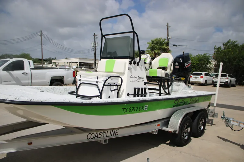 Slide: The Image of 2018 Shallow Stalker 204 RC boat on trailer, featuring green accents and Suzuki engine. - 2