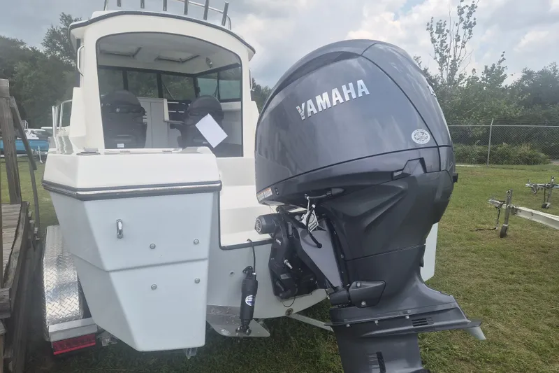Slide: The Image of 2027 Arima Sea Ranger 21 Yellowtail Edition with Yamaha outboard motor, parked on grass. - 3