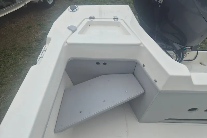 Slide: The Image of 2027 Arima Sea Ranger 21 Yellowtail Edition boat interior with storage compartment and motor. - 7