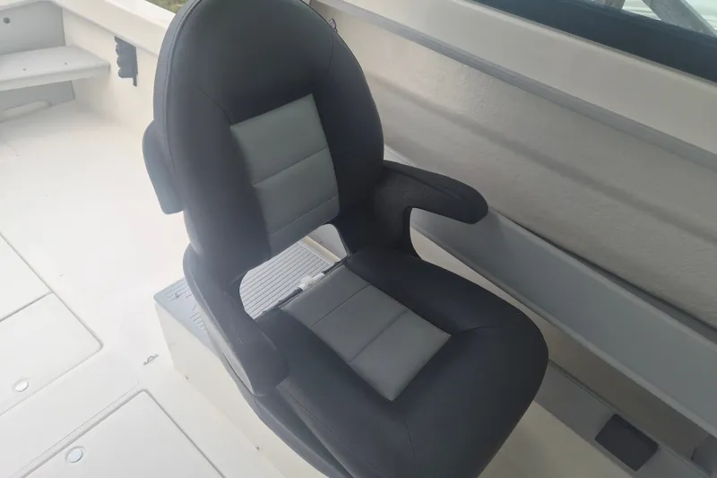 Slide: The Image of Captain's chair on 2027 Arima Sea Ranger 21 Yellowtail Edition boat, featuring sleek black and gray design. - 17